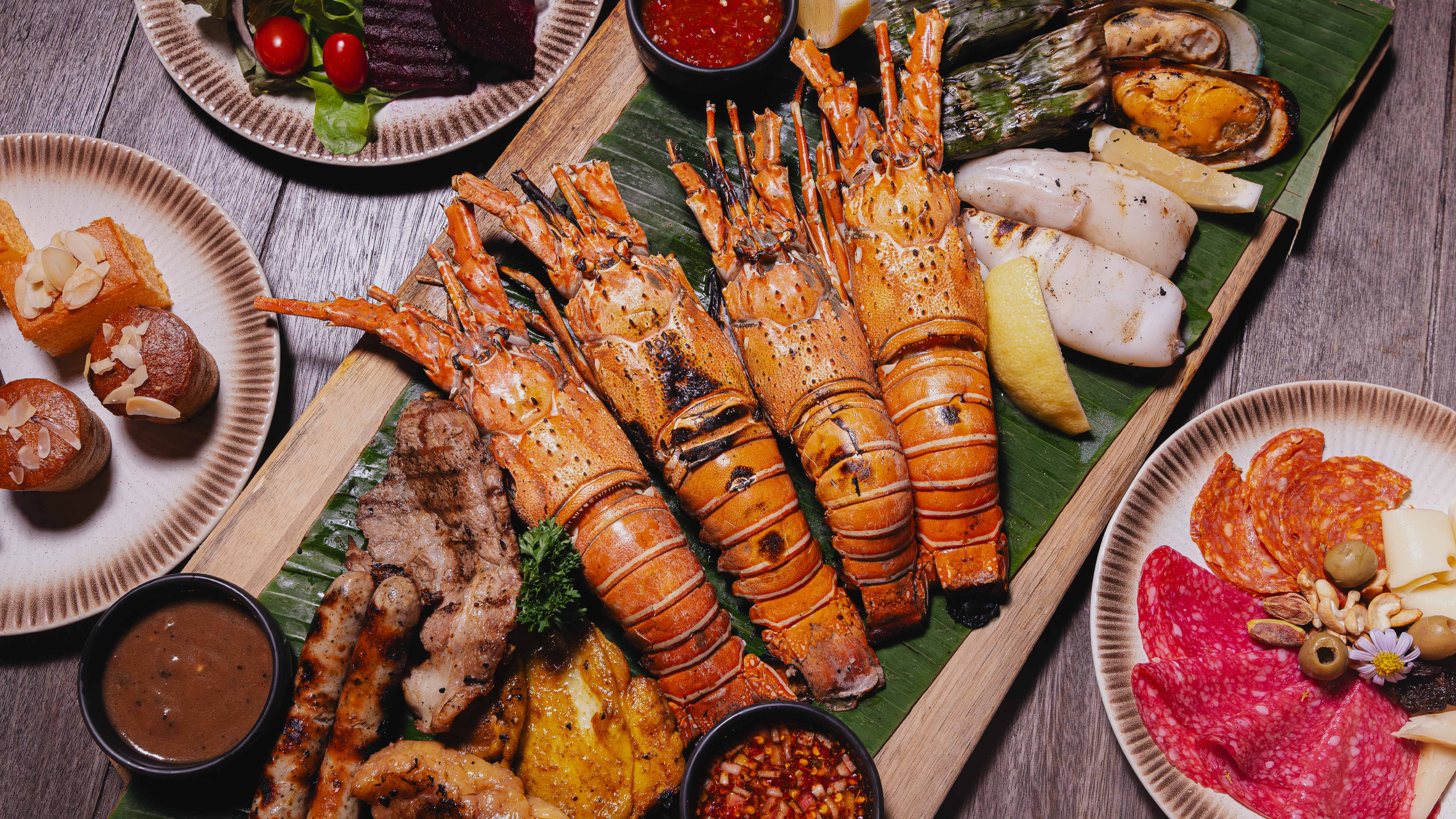 Experience Unlimited Lobster Night with Phuket lobster, BBQ seafood, premium meats, oysters, fine cheeses, and live music, enjoyed by the lake with refreshing breezes and live cooking stations.